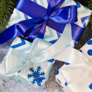 Presents wrapped under the tree in blue and white paper.